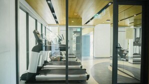 Ein modernes Fitnessstudio mit Laufbändern, Trainingsgeräten und Glaswänden.