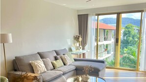 Ein modernes Wohnzimmer mit Sofa, Couchtisch und Blick auf einen Balkon.