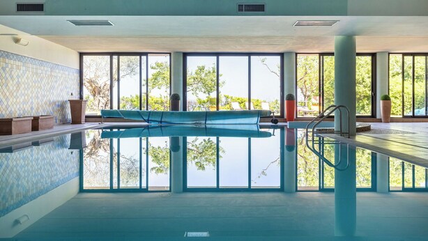 Ein Hallenbad mit klaren Fenstern, einer gefliesten Wand und einer blauen Matte.