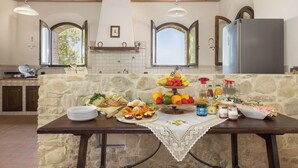 Eine Steinküche mit Frühstücksbuffet, einschließlich Gebäck, Früchten und Beilagen.