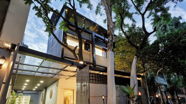 A modern building with a glass entrance, a metal gate, and a well-lit interior. - Chembur Homeotel - Gagal Home (Mumbai)