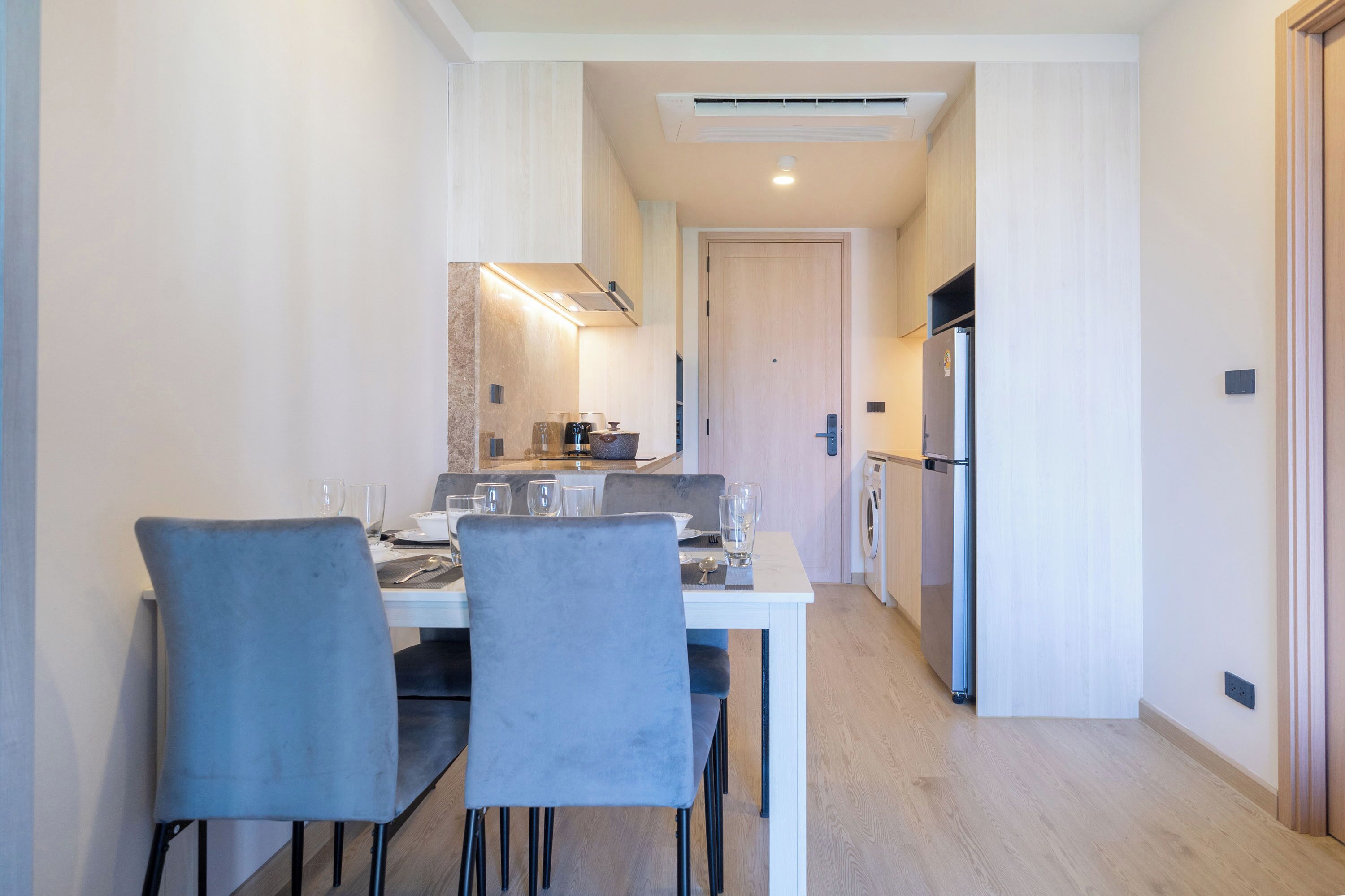 Una cocina moderna con comedor, horno empotrado y refrigerador.