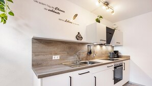 Una cocina moderna con armarios blancos, encimera de madera, un fregadero y una estufa.