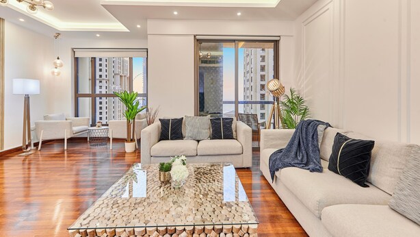 A modern living room with a sofa, a coffee table, and a chandelier.