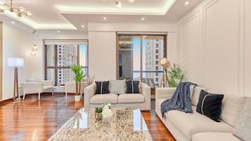 A modern living room with a sofa, a coffee table, and a chandelier.