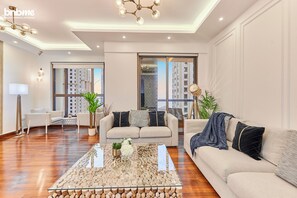Apartamento luxo, vista parcial para o mar | Área de estar | TV de tela plana 55 polegadas com canais a cabo