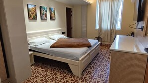 Una habitación de hotel con cama, baño y ventilador de techo.