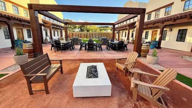 An outdoor patio area with a wooden pergola, seating arrangements, and a fire pit. - Casa De Hot Springs (La Verkin)