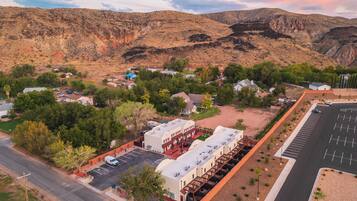 A town with a main road, a parking lot, and buildings with a mix of residential and commercial properties.
