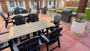 An outdoor patio with a table and chairs, a grill, and a potted plant. - Casa De Hot Springs (La Verkin)