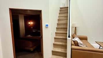 Una escalera conduce a una sala de estar con un sofá y una lámpara.