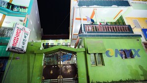 A gated entrance with a sign for 'A.C. & NON A.C. ROOMS' and a building with 'ONYX' branding. - Hotel Sriram Guest House OD (Puri)