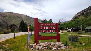 A sign for Sportsman's Cabins RV Sites with a gravel path leading to the entrance.