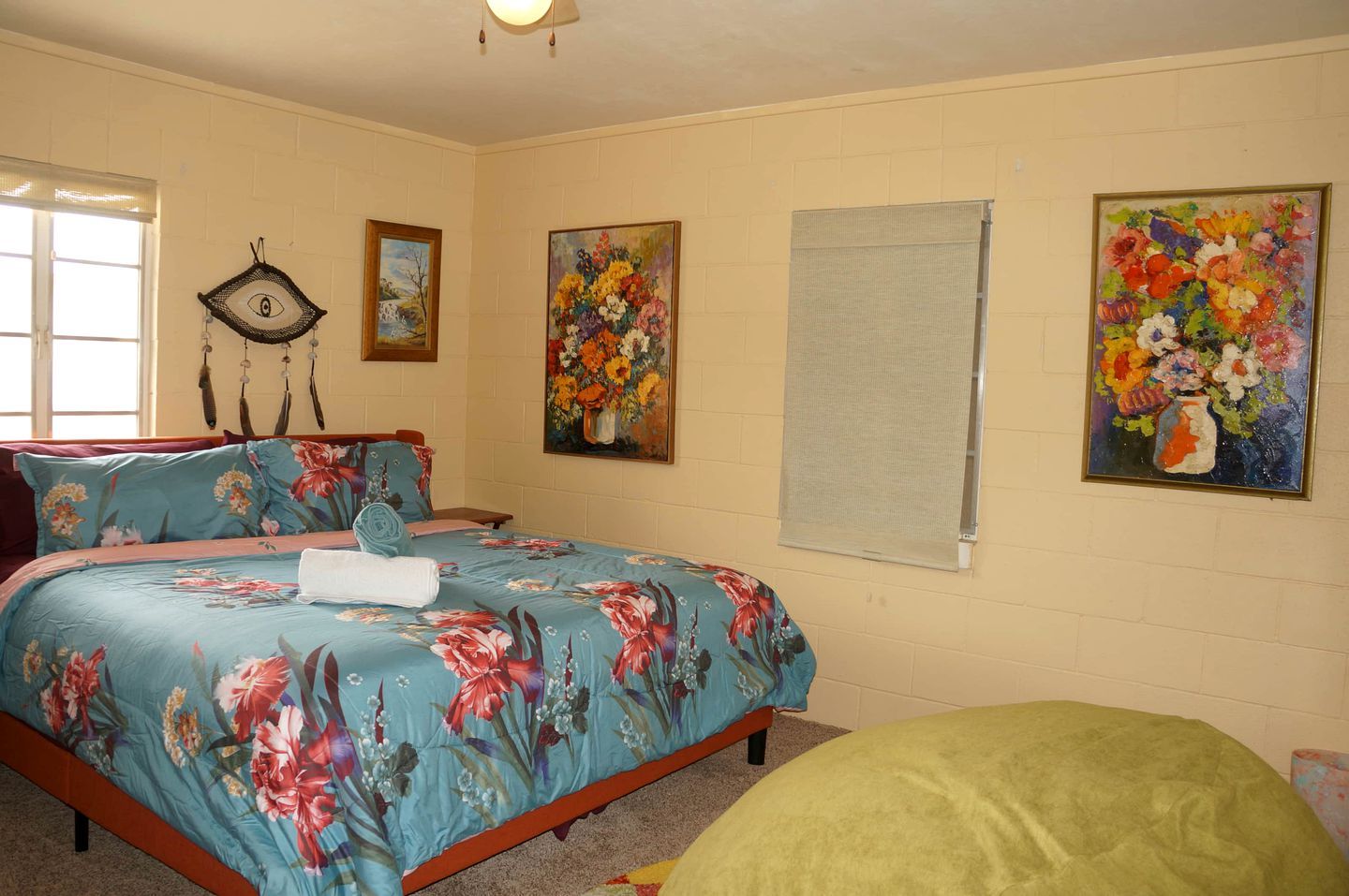 Un dormitorio con cama, ventana y decoración en la pared.