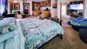 Ein Schlafzimmer mit Bett, Schreibtisch, Stuhl, Bücherregal und einem Fenster mit Blick.