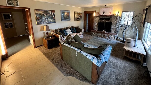 Una sala de estar con chimenea, sofá, una mesa de centro y televisión.