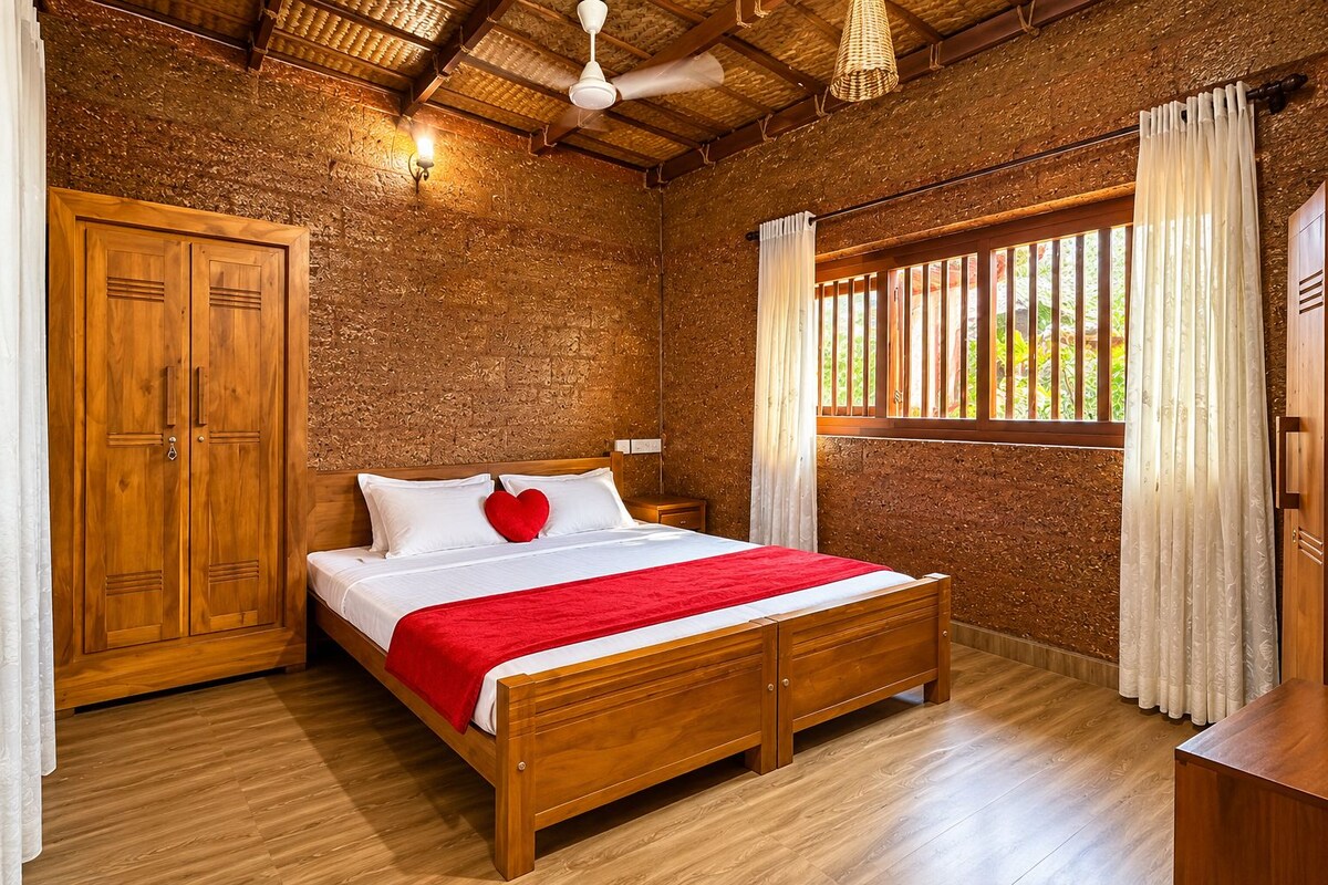 A bedroom with a wooden bed, a wardrobe, a ceiling fan, and a window with curtains.