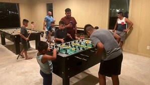 A room with pool tables, a foosball table, and a ceiling fan. - Luxury Tented Cabin Retreat - Fun Glamping Vacation by the Water for the Whole Family in Seguin, Texas (Seguin)