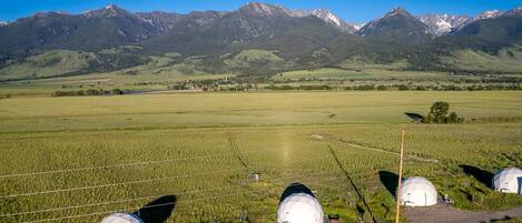 A rural landscape with a field, a road, and a mountain range in the background.