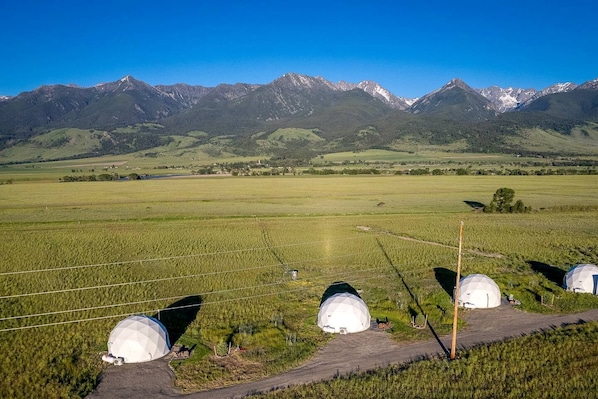 A rural landscape with a field, a road, and a mountain range in the background.