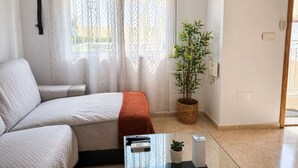 A room with a bed, a potted plant, a remote control, and a light switch on the wall. - Orihuela Costa Relax & Sea (Alicante)