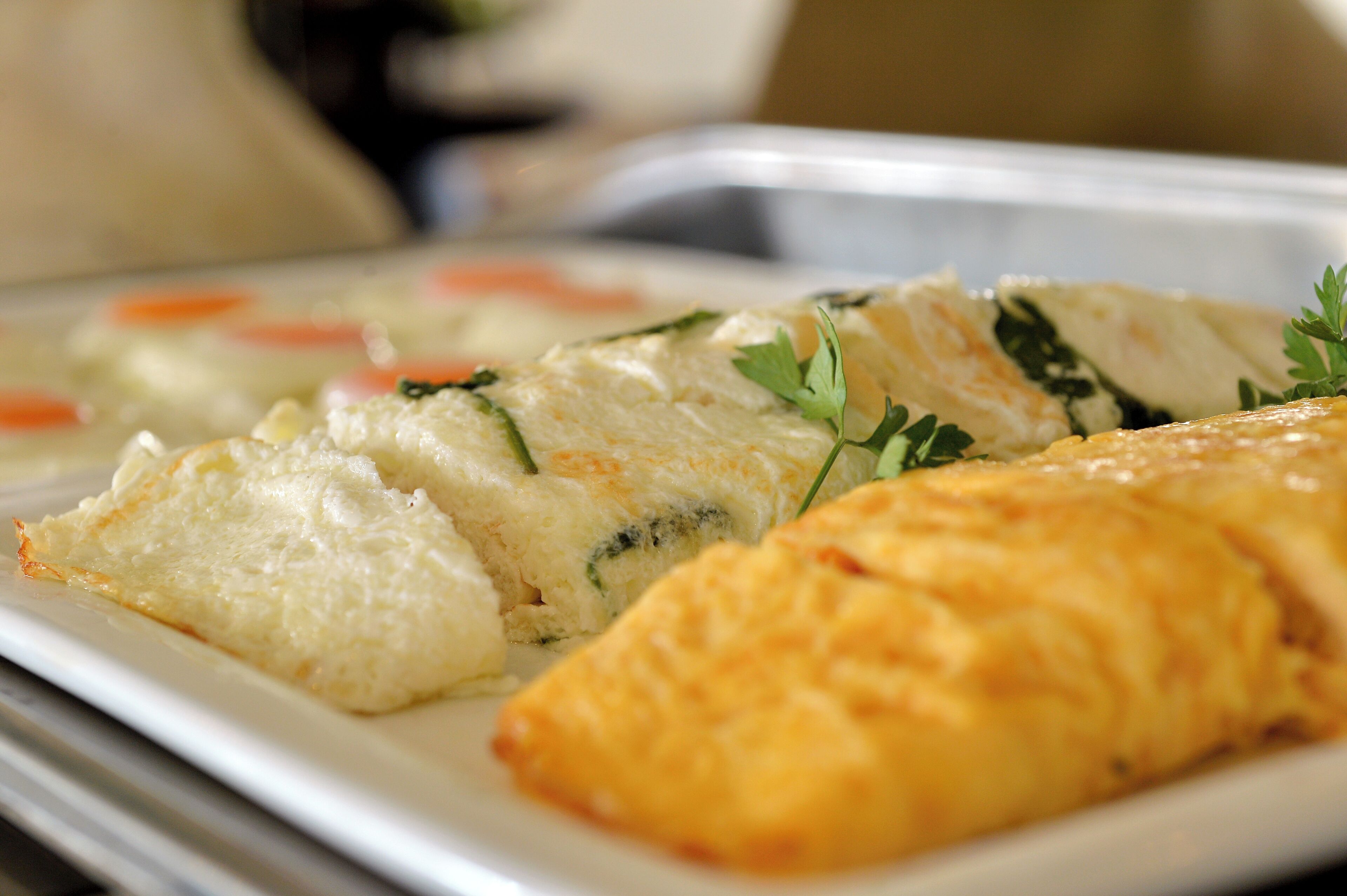 A plate with a baked dish and a pastry, garnished with herbs.