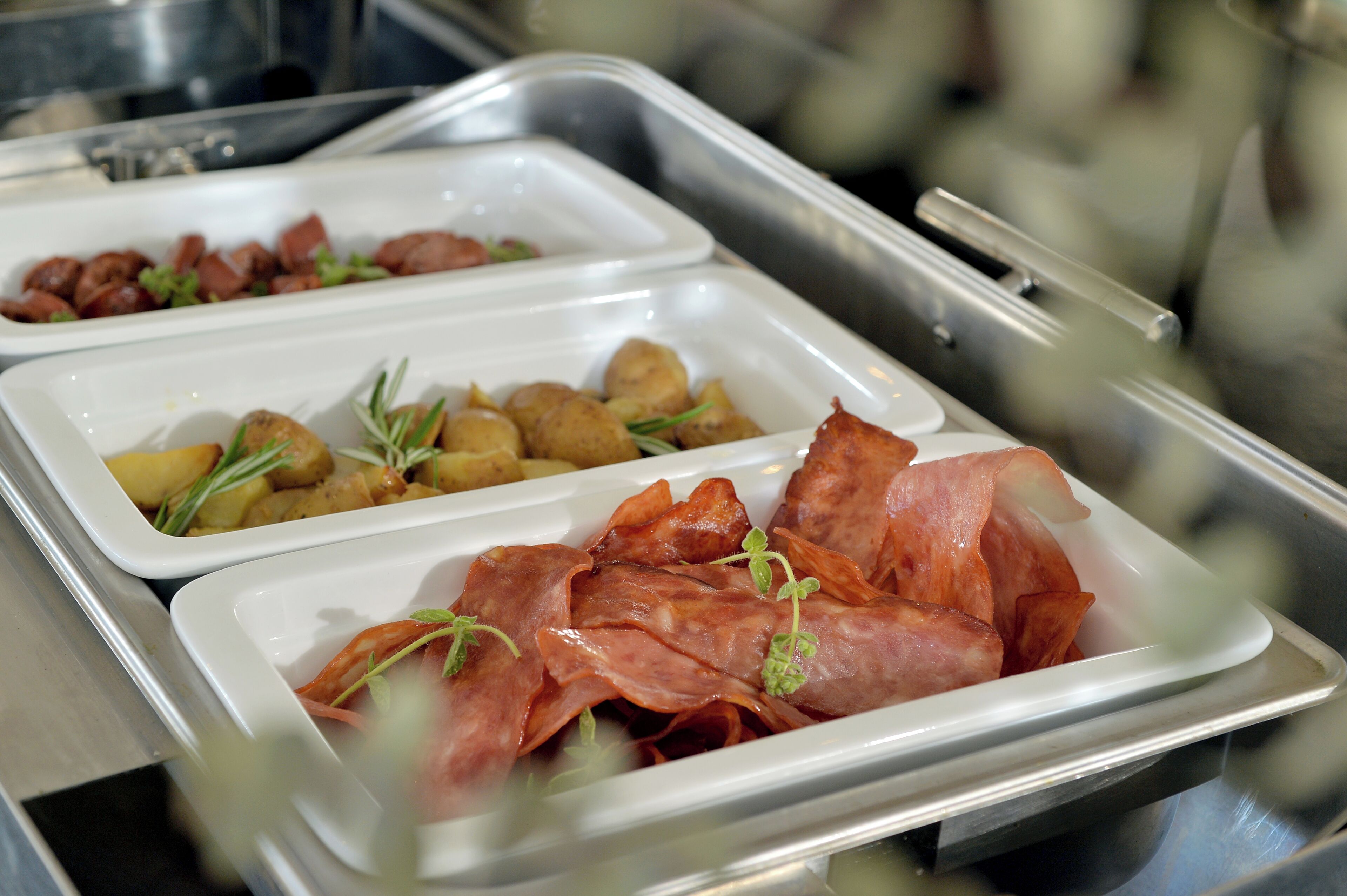 Un buffet proposant une variété de plats, notamment des viandes, des pommes de terre et des accompagnements.