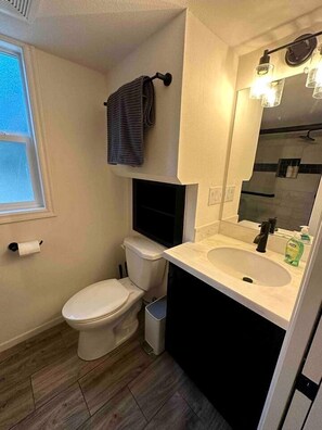 Ein kleines Badezimmer mit Toilette, Waschbecken und Spiegel.