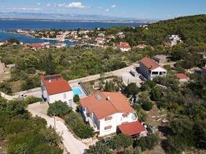 A residential area with houses, a swimming pool, and a view of the sea. - Charming Apartment Secret Garden (Lukoran)