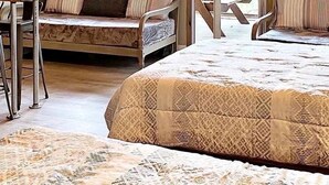 Una habitació amb tenda, amb un llit, una taula i una cadira.