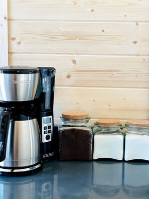 A coffee maker, a digital scale, and spice jars on a countertop. - Gorgeous A-Frame Cabin Nestled in the Trees near Lost River, West Virginia (Mathias)