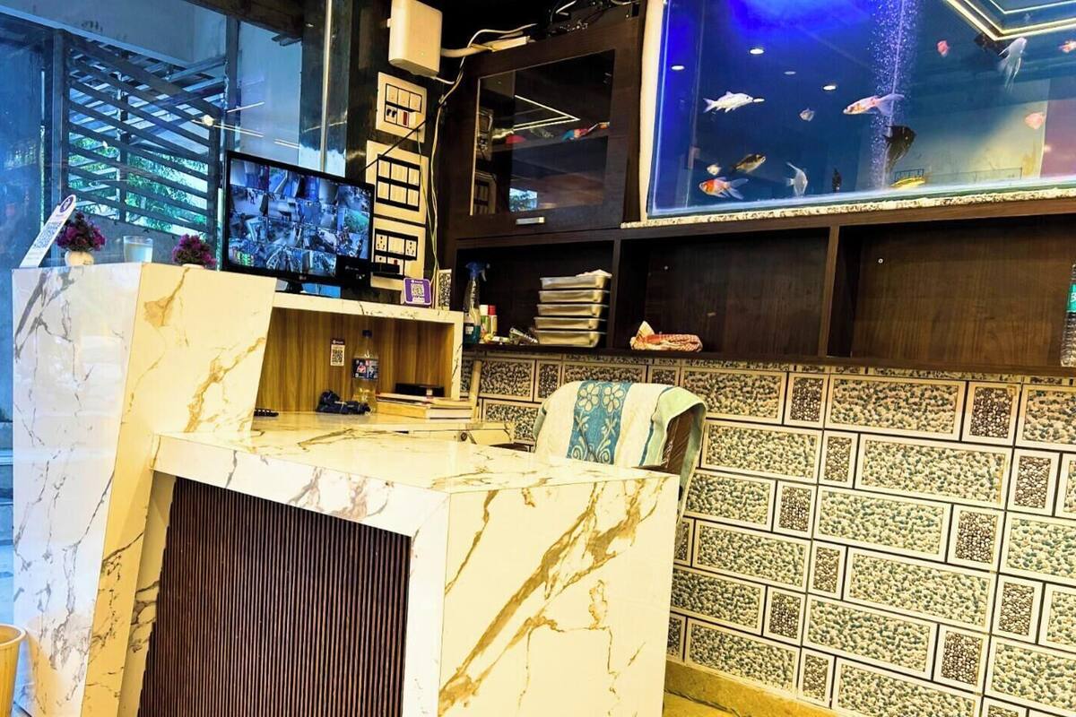 A reception desk with a marble top, a computer monitor, and a fish tank in the background.