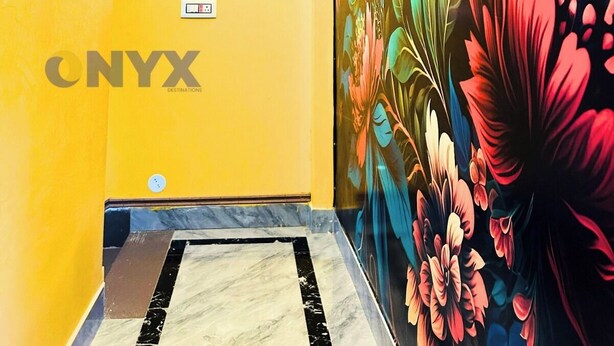 Un pasillo con pared amarilla, un mural floral y suelo de mármol.