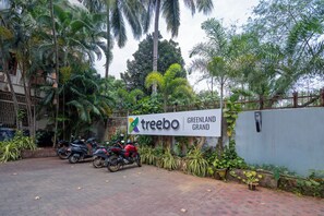 A sign for 'Treebo Greenland Grand' with a paved entrance and parked motorcycles. - Treebo Greenland Grand (Bhubaneshwar)
