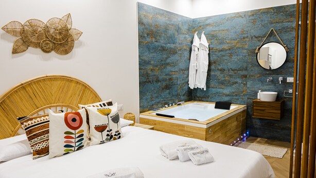 A modern bathroom with a bathtub, a mirror, and a wooden vanity.