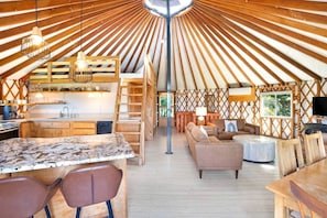 A spacious interior with a kitchen, dining area, and seating.