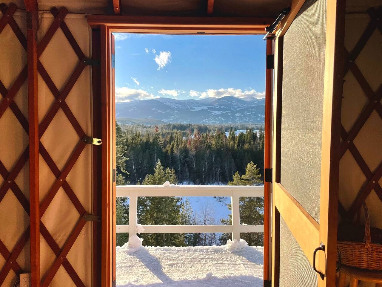 A room with a view of a snowy landscape and mountains.