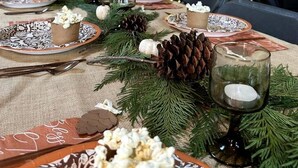 A festive indoor setting with a Christmas tree, a long dining table set with plates, candles, and pine cones. - Cozy Mountain Yurt with Panoramic Views near Selkirk Mountains, Sandpoint Idaho (Sandpoint)