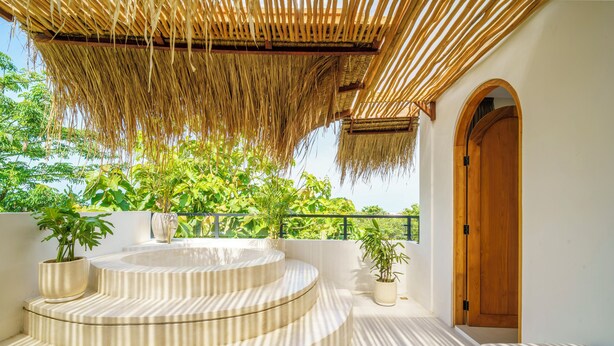 A spa area with a wooden door, a thatched roof, and a pool with steps. - Stunning 3BR Villa • Rooftop Pool • 3min to Beach Balangan (Badung)