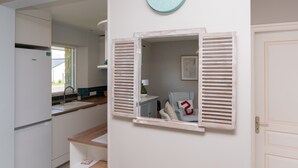 Una cocina con ventana, un reloj y una puerta.
