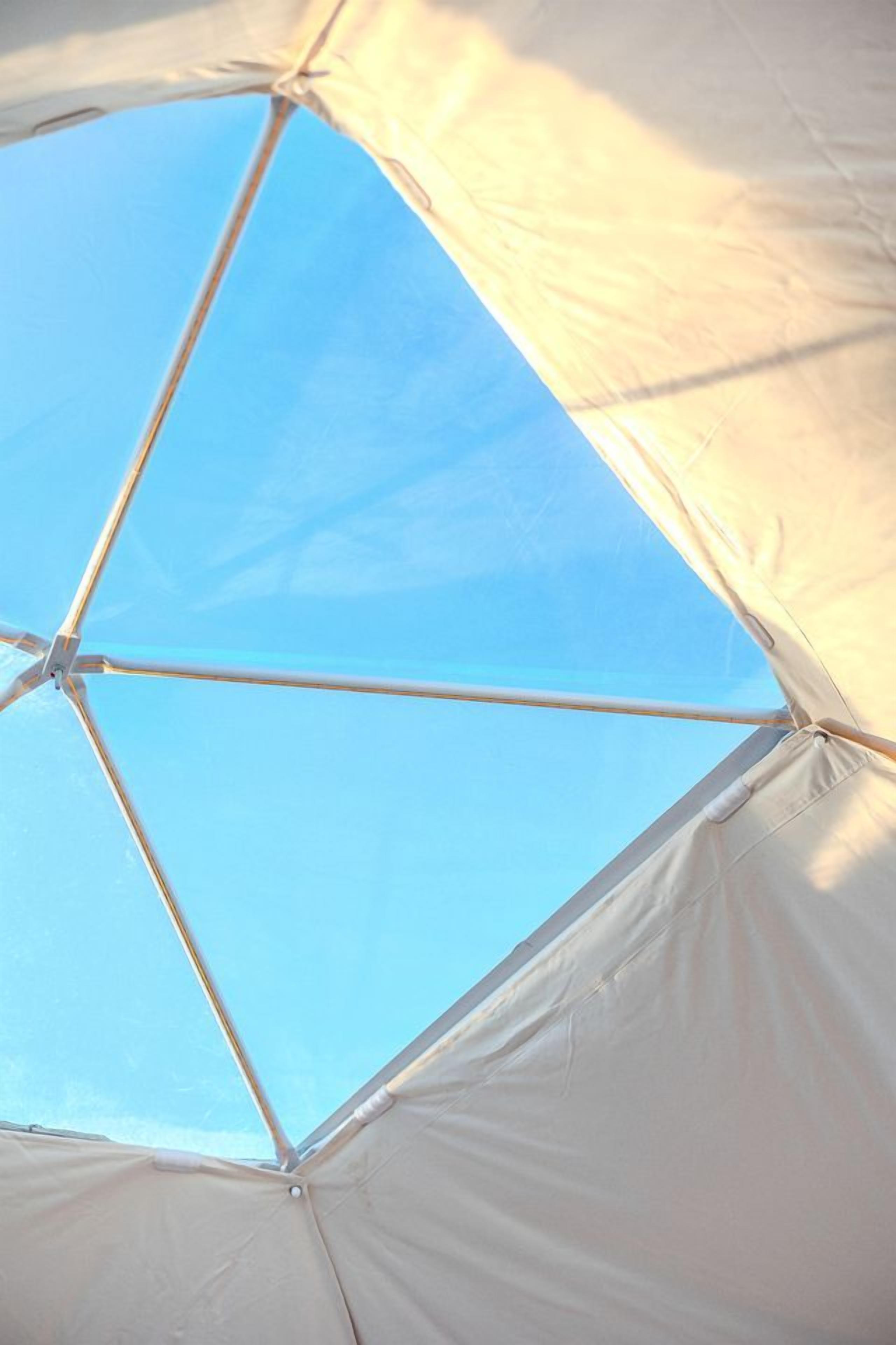 Una tenda con un cielo azzurro visibile attraverso gli spazi.
