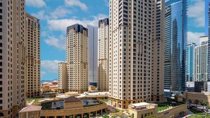 A high-rise residential building complex with multiple floors, a central courtyard, and surrounding modern high-rise buildings. - LUX LIV Contemporary Skyline Studio (Dubai)