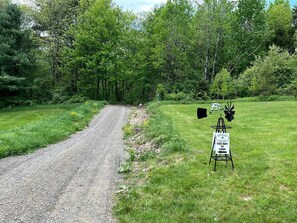A gravel path leading to a campsite with a sign indicating the way to the camp.