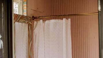 A bathroom with a white sink, a gold faucet, and a shower curtain.