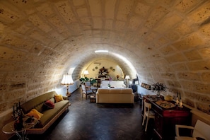 A cozy, arched room with a sofa, armchair, and a small table with a lamp. - Tenuta Renna by Geco Vacation Rentals (Ragusa)