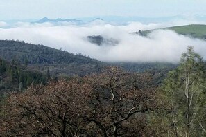 Un paisaje montañoso con bosques densos y vistas a montañas distantes.