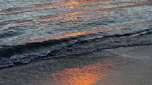 A sunset over a calm sea with a boat in the distance. - Casa Amare by Geco Vacation Rentals (Agnone)