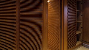 Ein Schrank aus Holz mit horizontalen Lamellen, einer Tür und einem Regal.