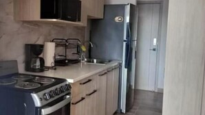 Una cucina con fornello, lavello e frigorifero.