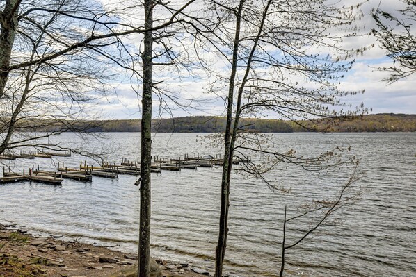 A lake with dock structures and trees in the foreground.
